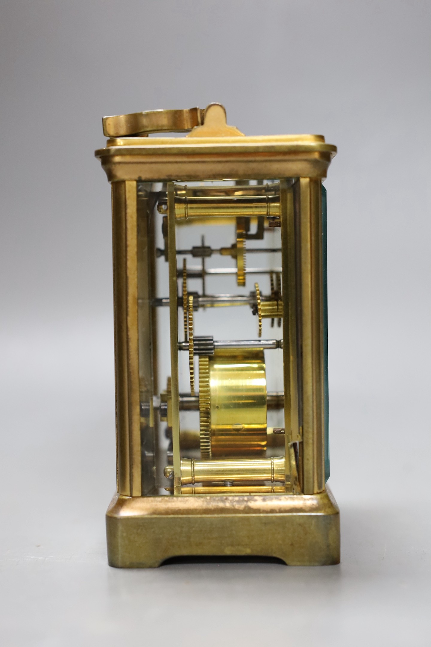 A leather cased brass carriage timepiece. 13cm tall